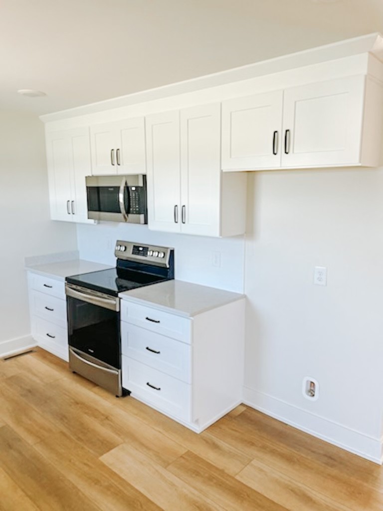 243 Tom Ferrell Road Portland, TN 37148 - Photo 11 of 17 a kitchen with white cabinets and black appliances