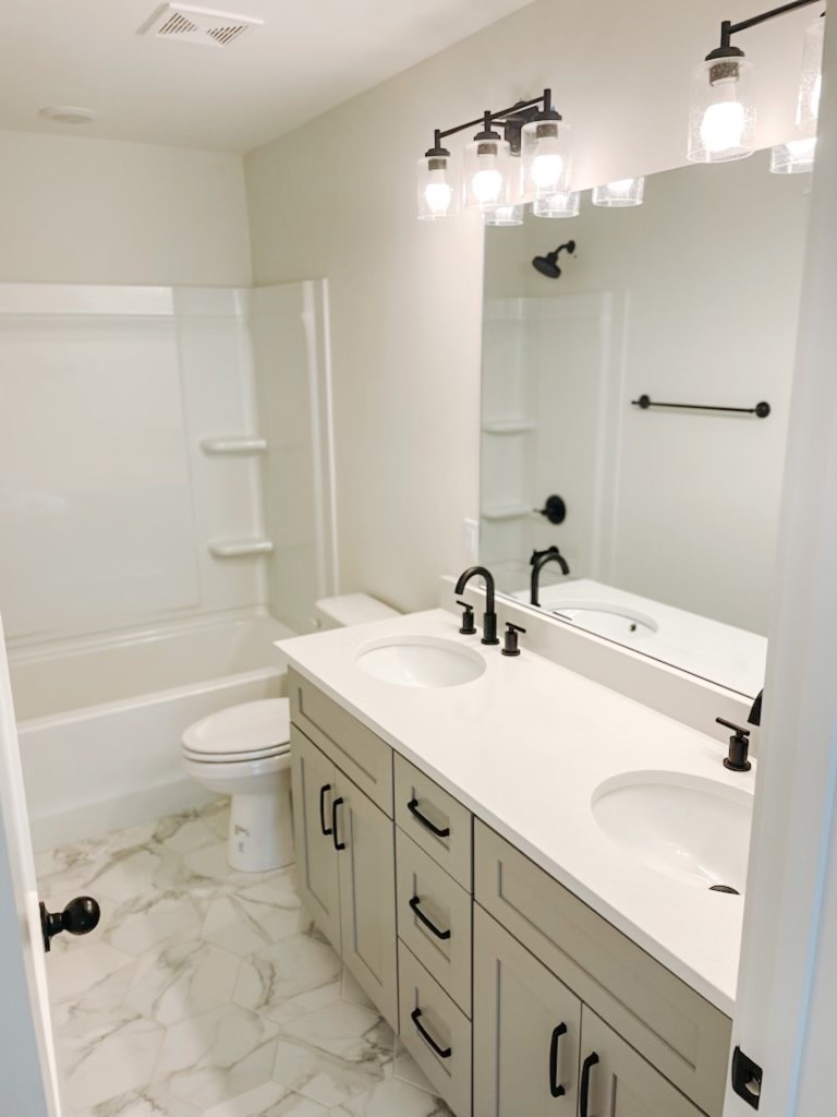 243 Tom Ferrell Road Portland, TN 37148 - Photo 13 of 17 a bathroom with a granite countertop sink a toilet a mirror and shower