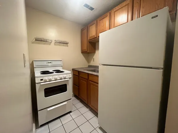 a white refrigerator freezer and a stove sitting inside of a kitchen