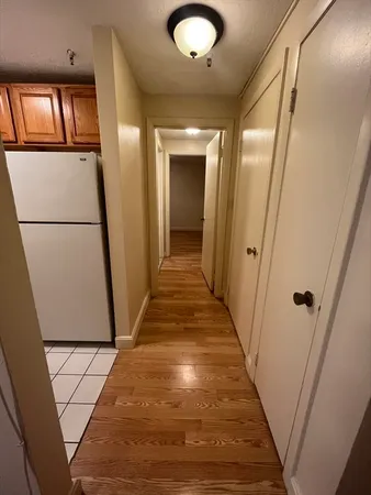 a view of a hallway with wooden floor and staircase