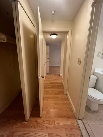 a view of a hallway with wooden floor and a living room