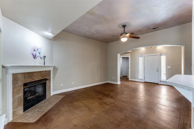 a view of an empty room with window and fireplace