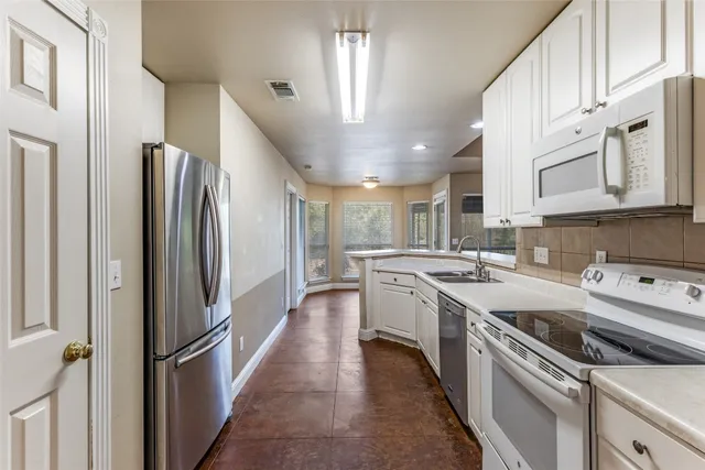 a kitchen with stainless steel appliances granite countertop a stove a sink and a refrigerator