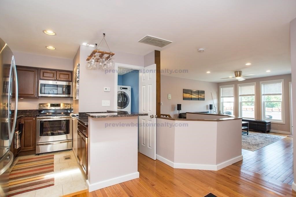 29 Brainerd Road, Unit 304 Boston, MA 02134 - Photo 1 of 22 a kitchen with stainless steel appliances kitchen island granite countertop a stove and a refrigerator