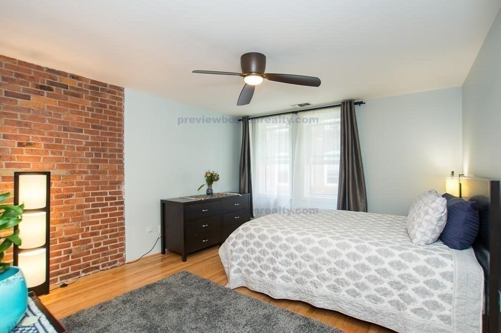 29 Brainerd Road, Unit 304 Boston, MA 02134 - Photo 16 of 22 a bedroom with a bed and dresser with mirror