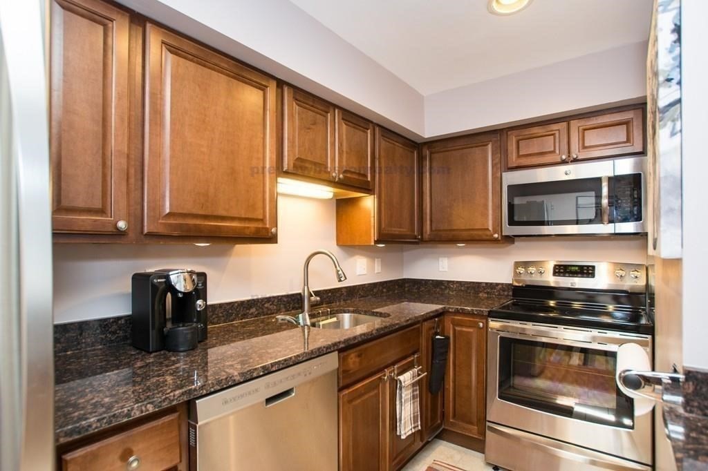 29 Brainerd Road, Unit 304 Boston, MA 02134 - Photo 4 of 22 a kitchen with granite countertop a sink a counter top space cabinets and stainless steel appliances