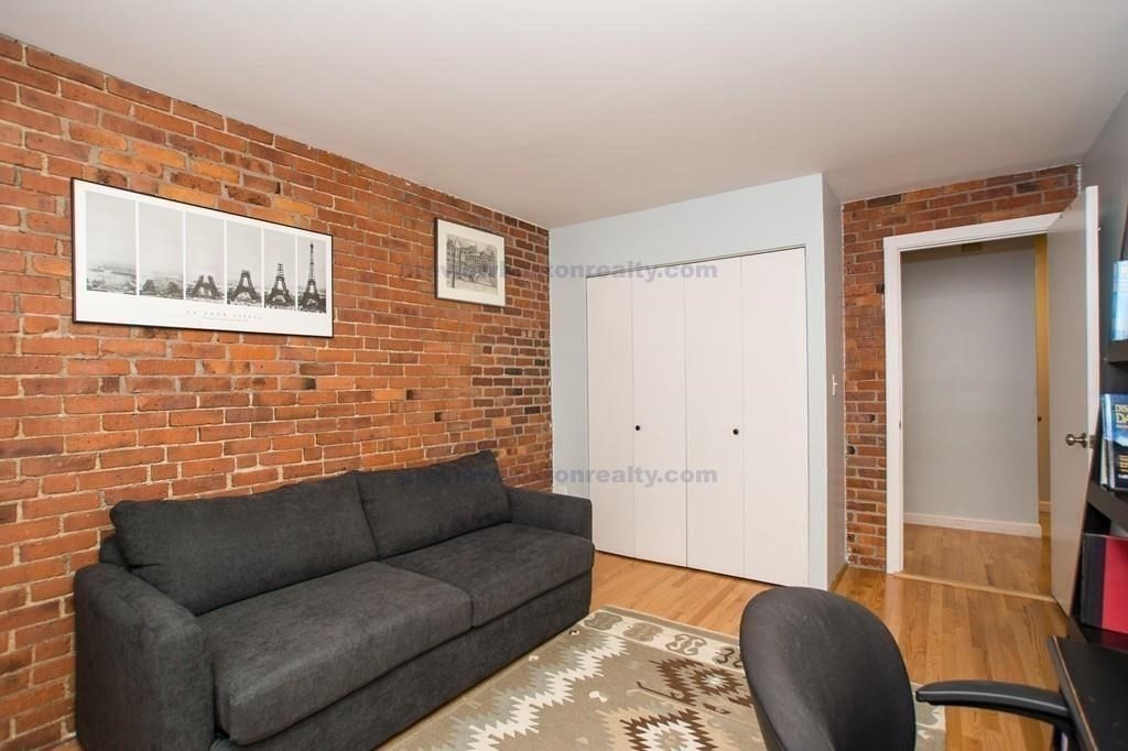 29 Brainerd Road, Unit 304 Boston, MA 02134 - Photo 6 of 22 a living room with furniture and a blue wall