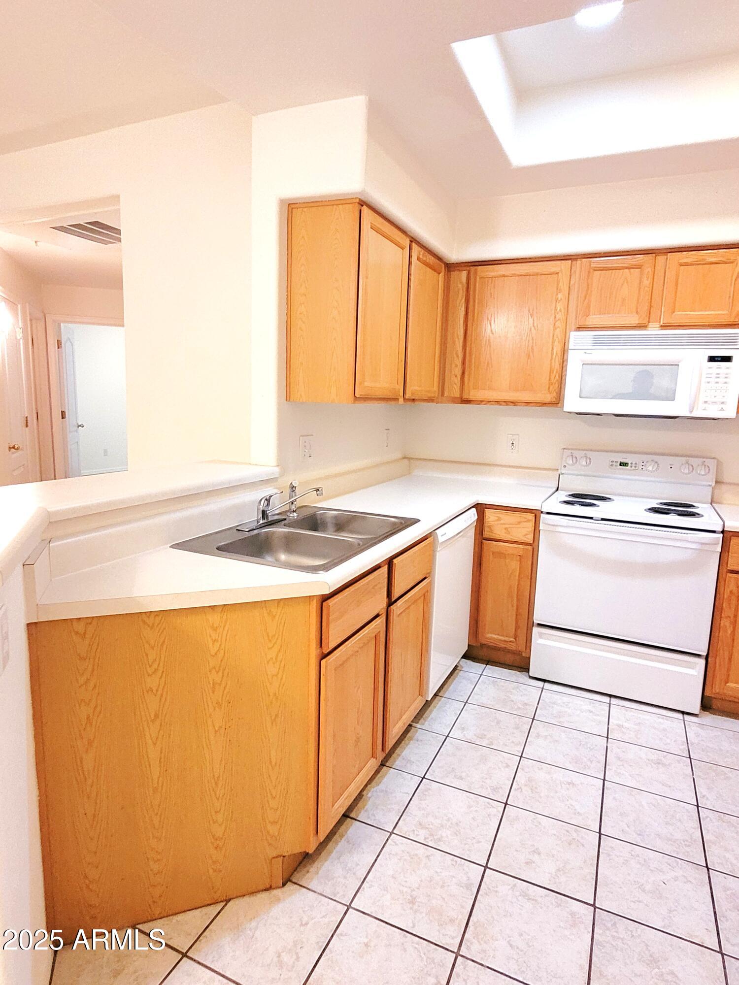 9151 West Greenway Road, Unit 152 Peoria, AZ 85381 - Photo 9 of 17 a kitchen with stainless steel appliances granite countertop a sink stove refrigerator and cabinets
