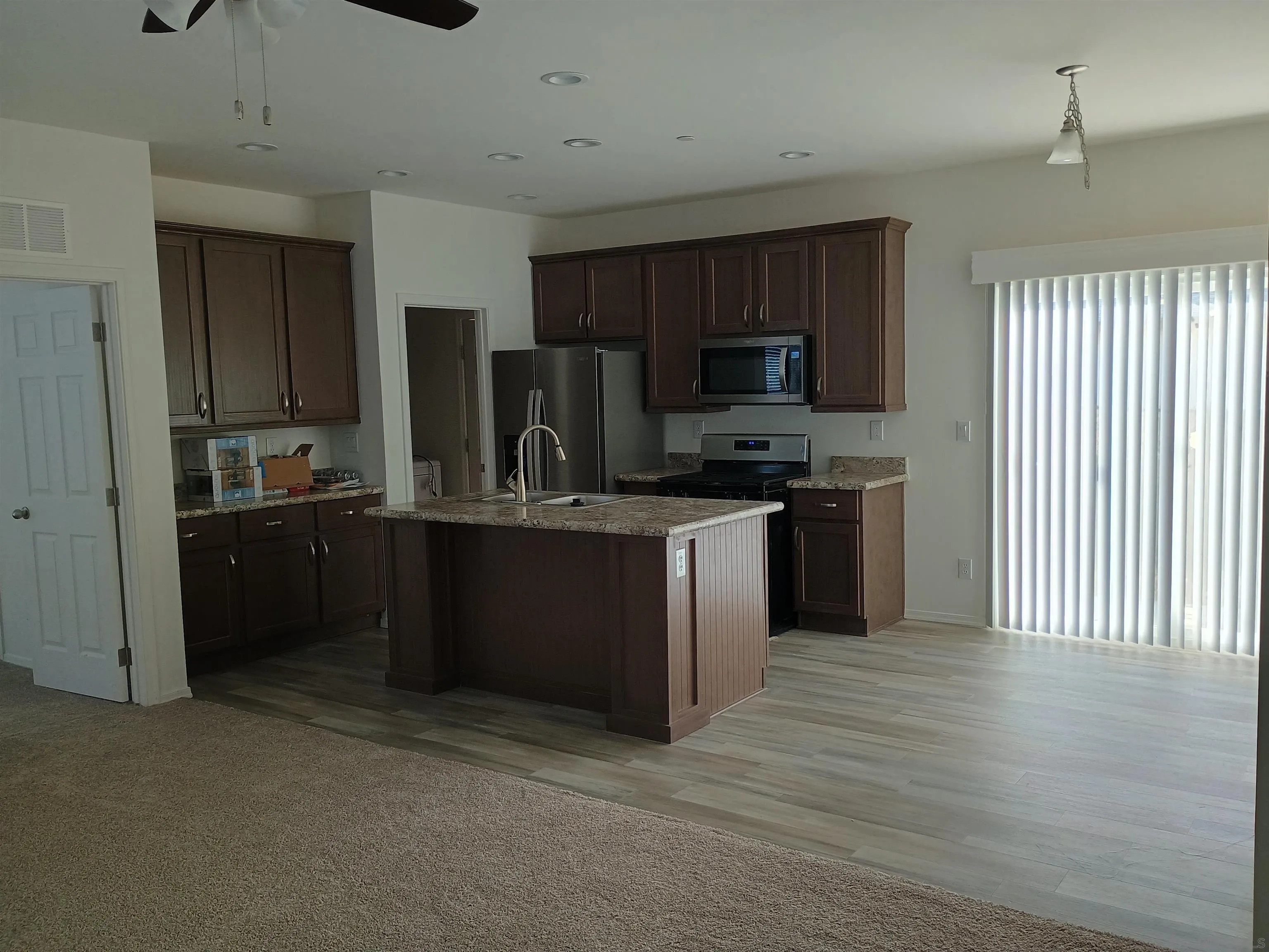 1040 Gillespie Drive Spring Valley, CA 91977 - Photo 3 of 6 a kitchen with kitchen island stainless steel appliances a sink stove refrigerator and cabinets