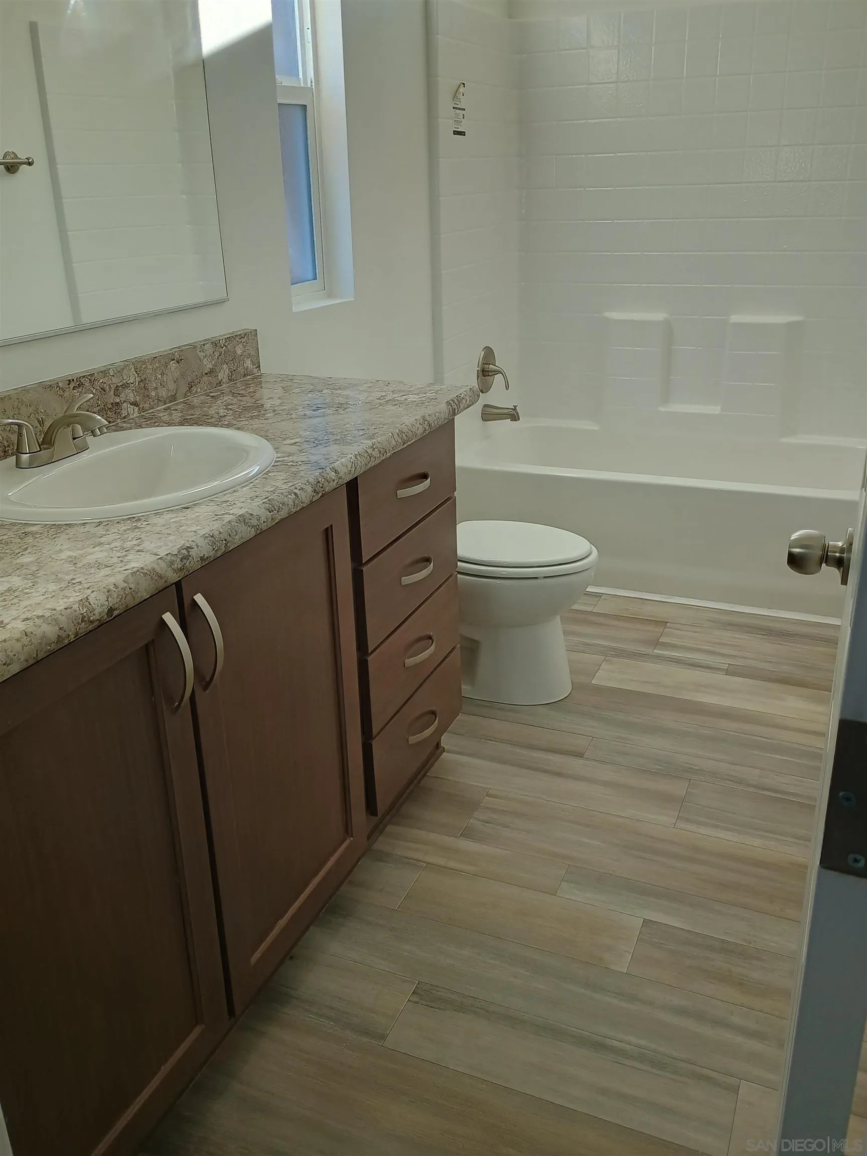 1040 Gillespie Drive Spring Valley, CA 91977 - Photo 5 of 6 a bathroom with a granite countertop sink toilet and shower