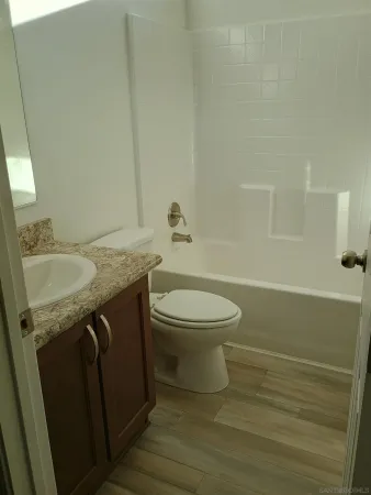 a bathroom with a granite countertop sink toilet and shower