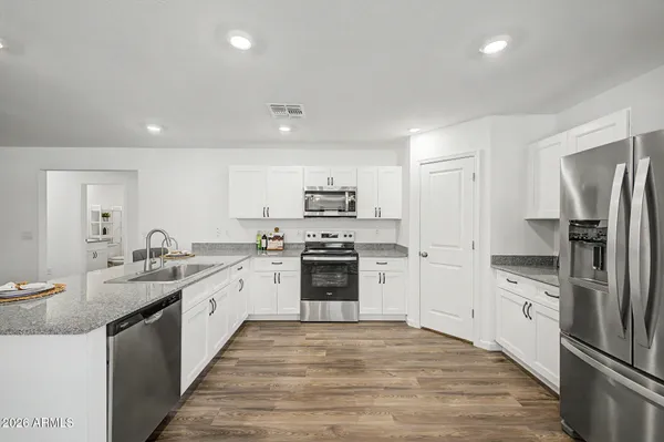 a large kitchen with a stove top oven and refrigerator
