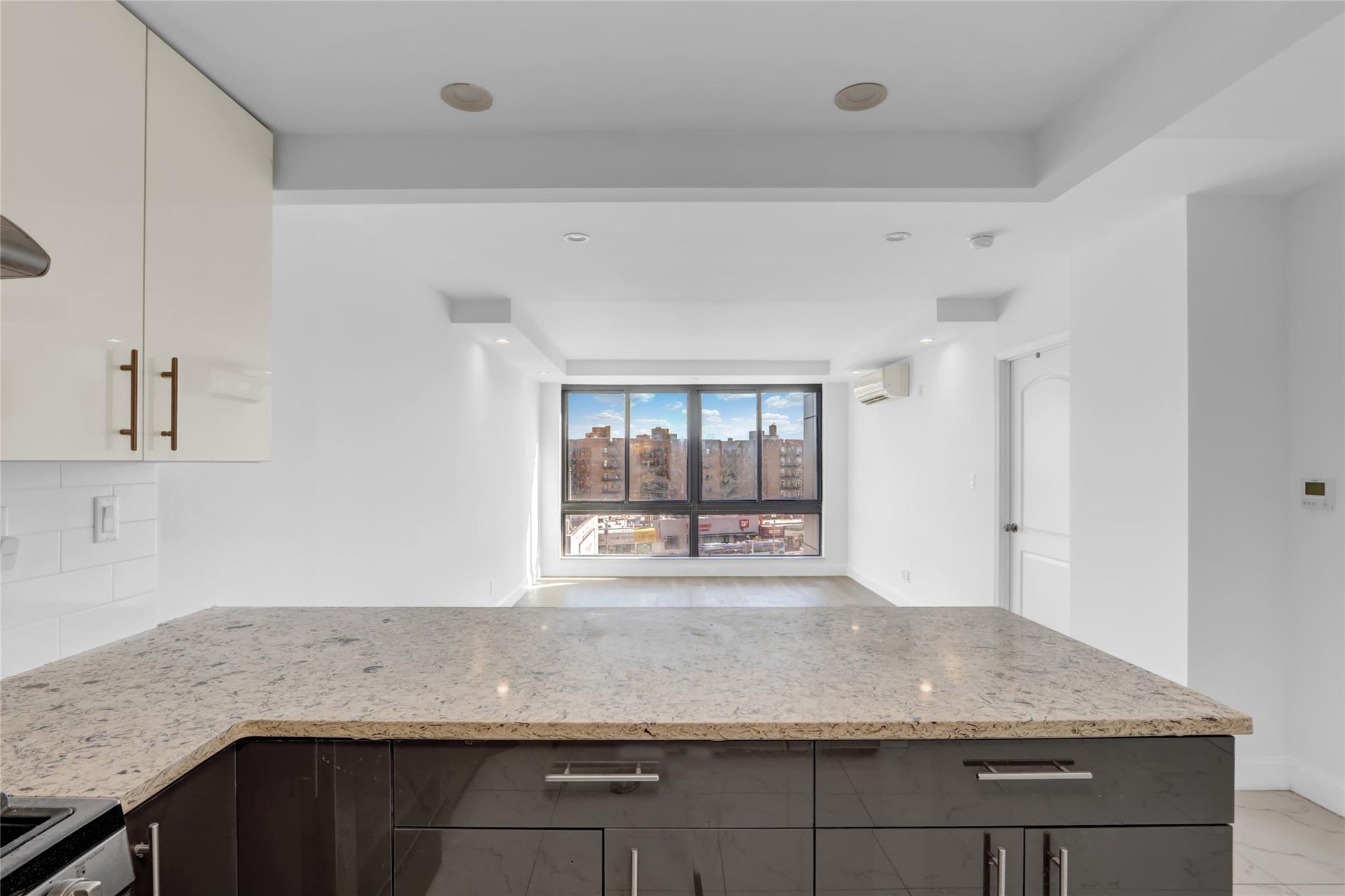 45-16 83rd Street, Unit E6J Queens, NY 11373 - Photo 5 of 19 Kitchen featuring range, an AC wall unit, backsplash, and light stone counters