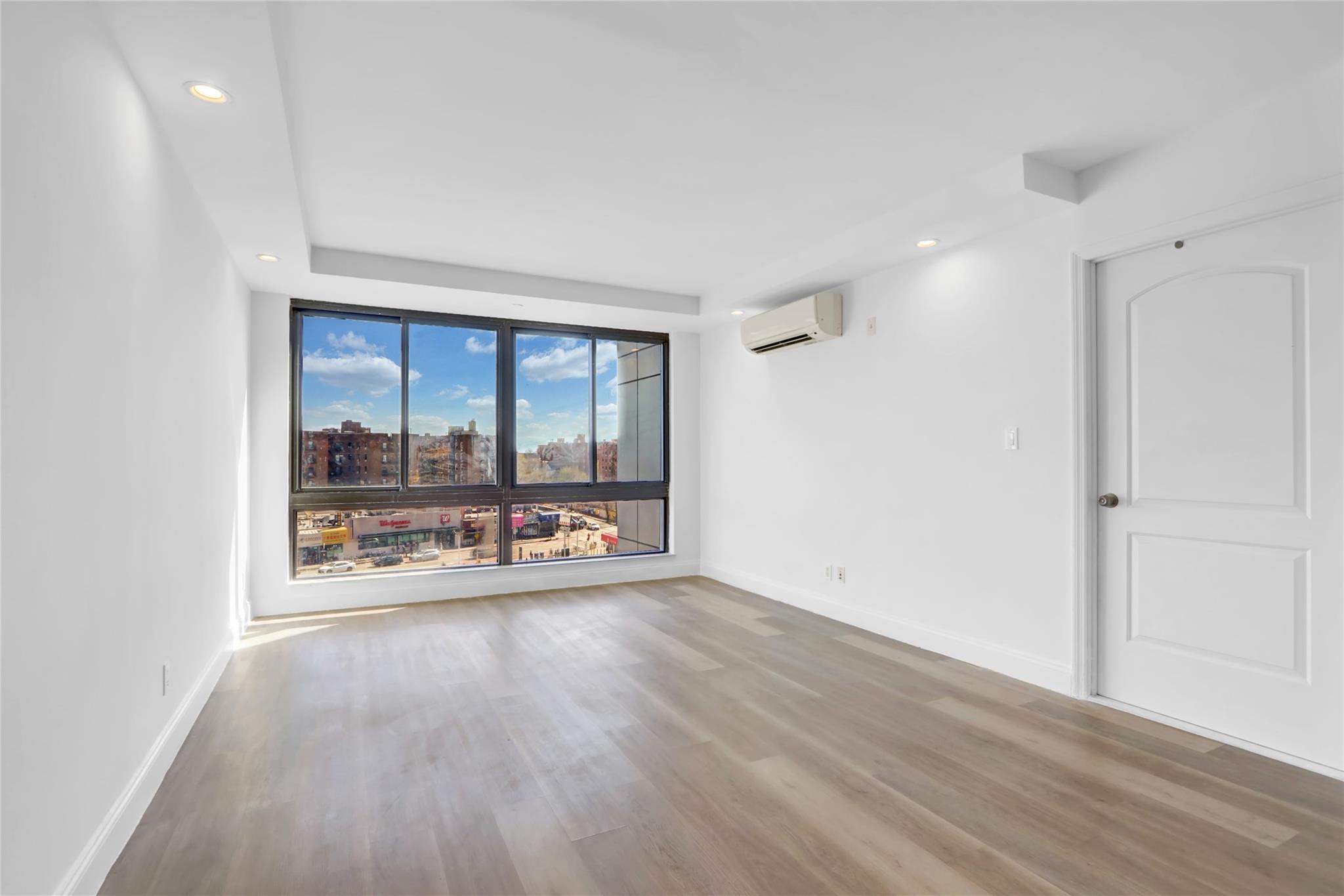 45-16 83rd Street, Unit E6J Queens, NY 11373 - Photo 7 of 19 Empty room with a wall mounted air conditioner, recessed lighting, baseboards, and wood finished floors