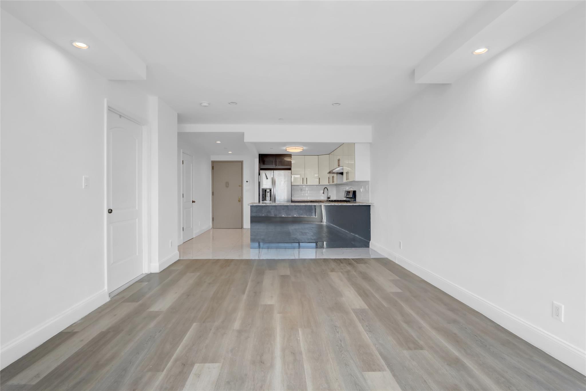 45-16 83rd Street, Unit E6J Queens, NY 11373 - Photo 8 of 19 Unfurnished living room featuring light wood-type flooring, baseboards, and recessed lighting