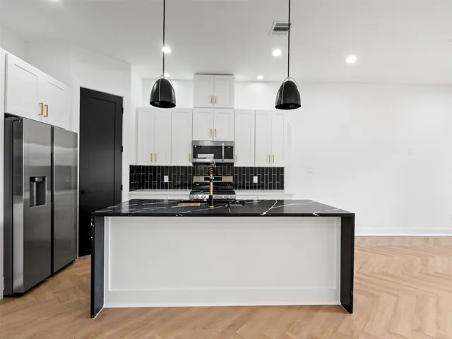 a kitchen with stainless steel appliances granite countertop a sink and a microwave