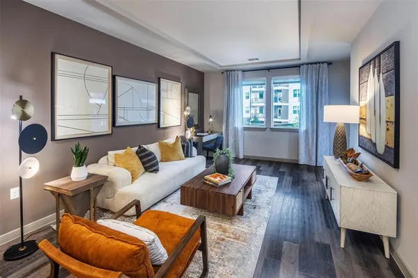 a living room with furniture a rug and a table