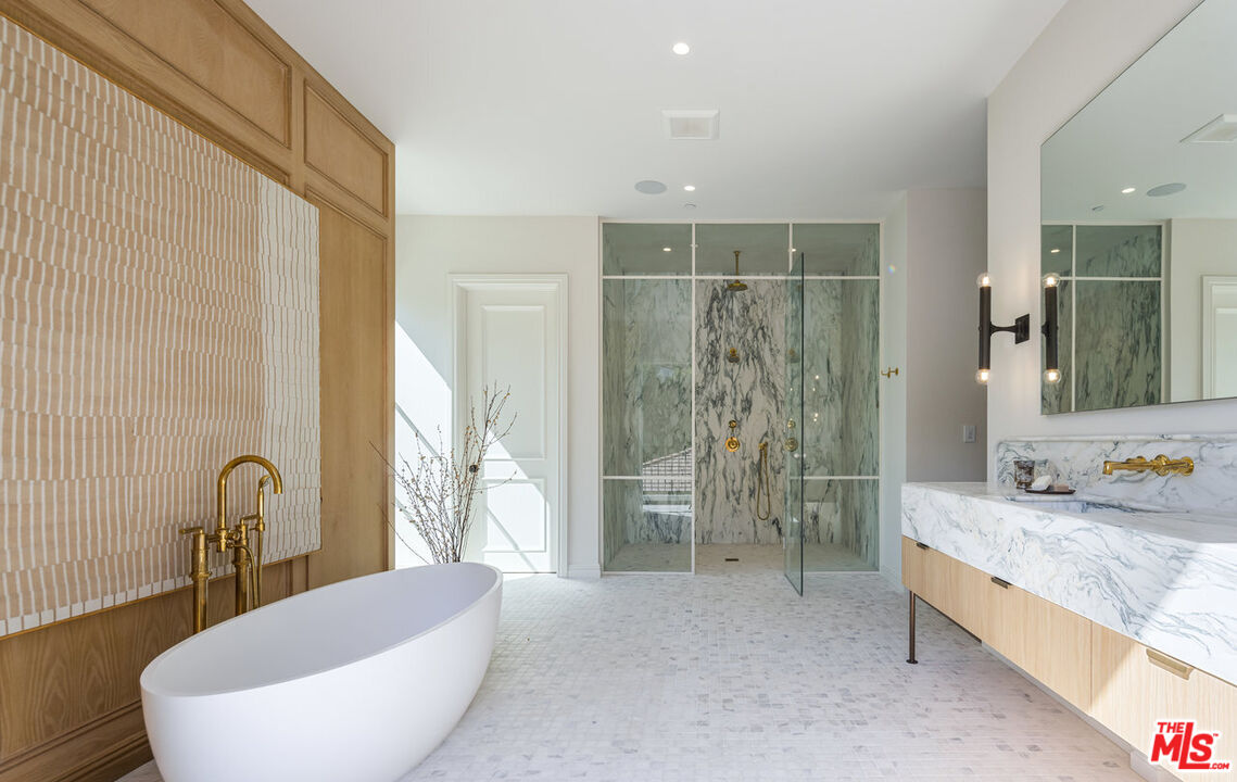 15620 Woodvale Road Encino, CA 91436 - Photo 23 of 37 a spacious bathroom with a granite countertop tub sink and mirror