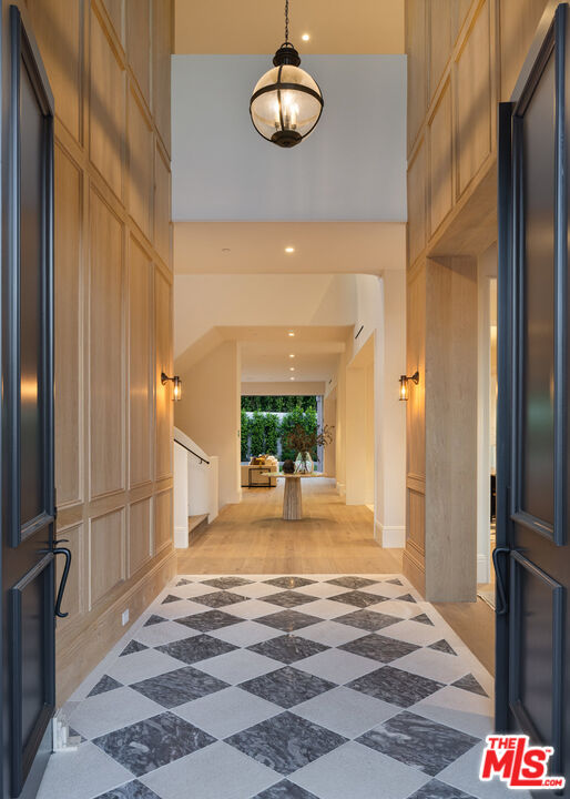 15620 Woodvale Road Encino, CA 91436 - Photo 7 of 37 a view of a hallway with wooden floor and a chandelier