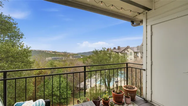 a view of a balcony with chairs and wooden fence