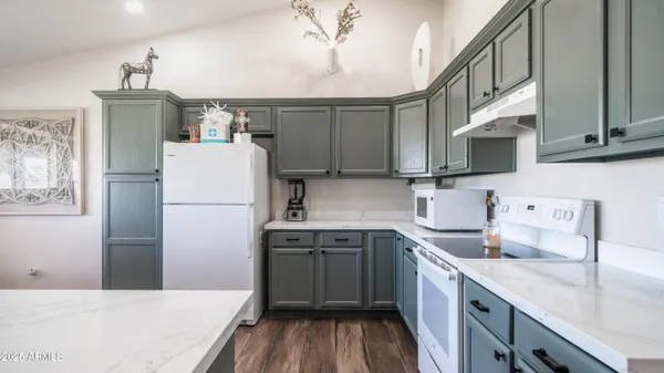 a kitchen with a sink a refrigerator and cabinets