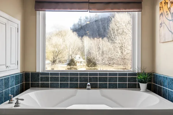a view of a bathtub and window in a room