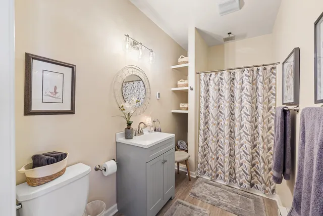 a bathroom with a toilet sink and shower curtain