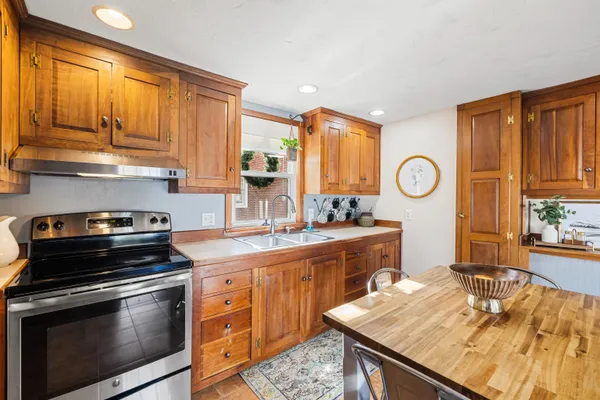 a kitchen with stainless steel appliances granite countertop a stove a sink and a microwave