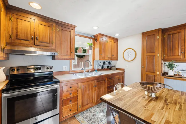 a kitchen with stainless steel appliances granite countertop a stove a sink and a microwave