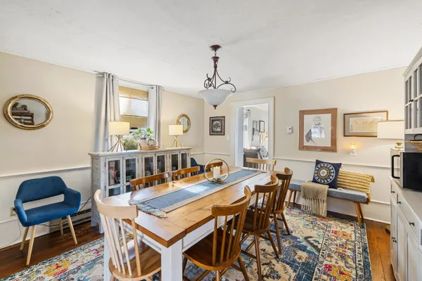 a kitchen with stainless steel appliances granite countertop a stove top oven a refrigerator a stove a dining table and chairs with wooden floor