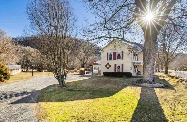 a view of a house with backyard water fountain and sitting area