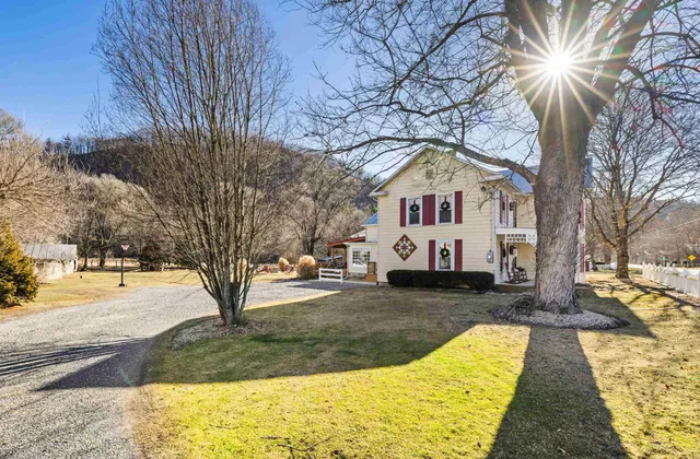 a view of a house with backyard water fountain and sitting area