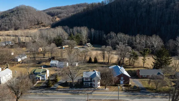 an aerial view of a house with yard and parking