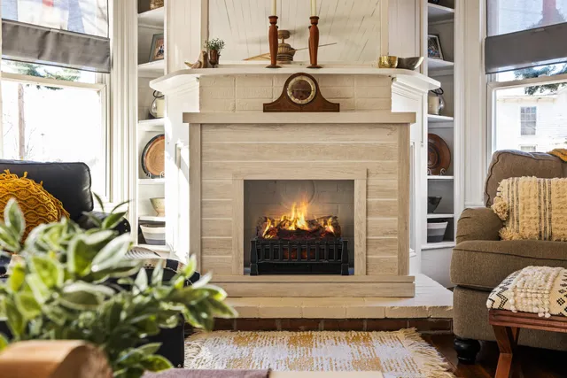 a view of living room with furniture and a fireplace