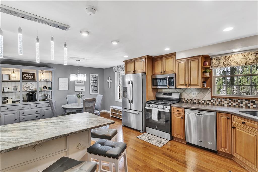 9 Quail Court Export, PA 15632 - Photo 20 of 35 Tile Backsplash, Leathered Granite Breakfast Bar, and Gorgeous Wood Floors in the 13x12 Kitchen.