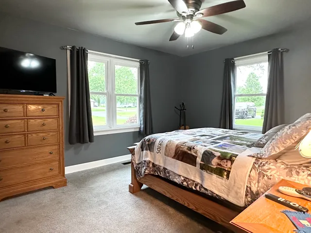 a bed sitting in a bedroom next to a window and a flat screen tv