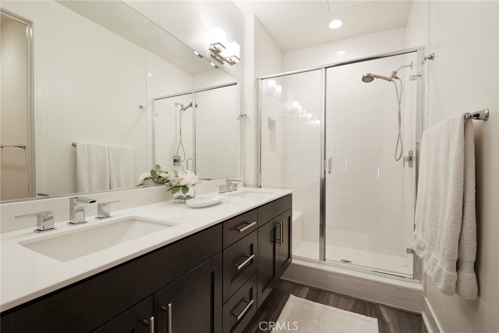 1648 Topanga Costa Mesa, CA 92627 - Photo 18 of 33 a bathroom with a double vanity sink a mirror a shower and a bathtub