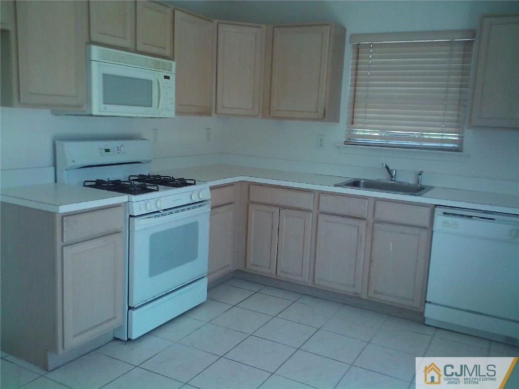 2101 Ridgeview Court, Unit 1 Sayreville, NJ 08859 - Photo 4 of 11 a kitchen with cabinets appliances a sink and a window