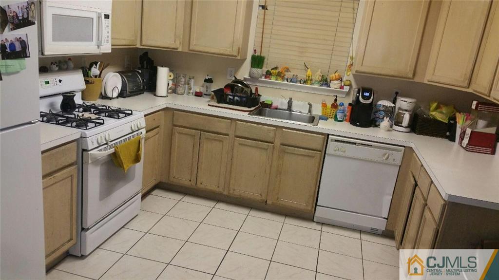 2101 Ridgeview Court, Unit 1 Sayreville, NJ 08859 - Photo 5 of 11 a kitchen with a sink a stove top oven and cabinets