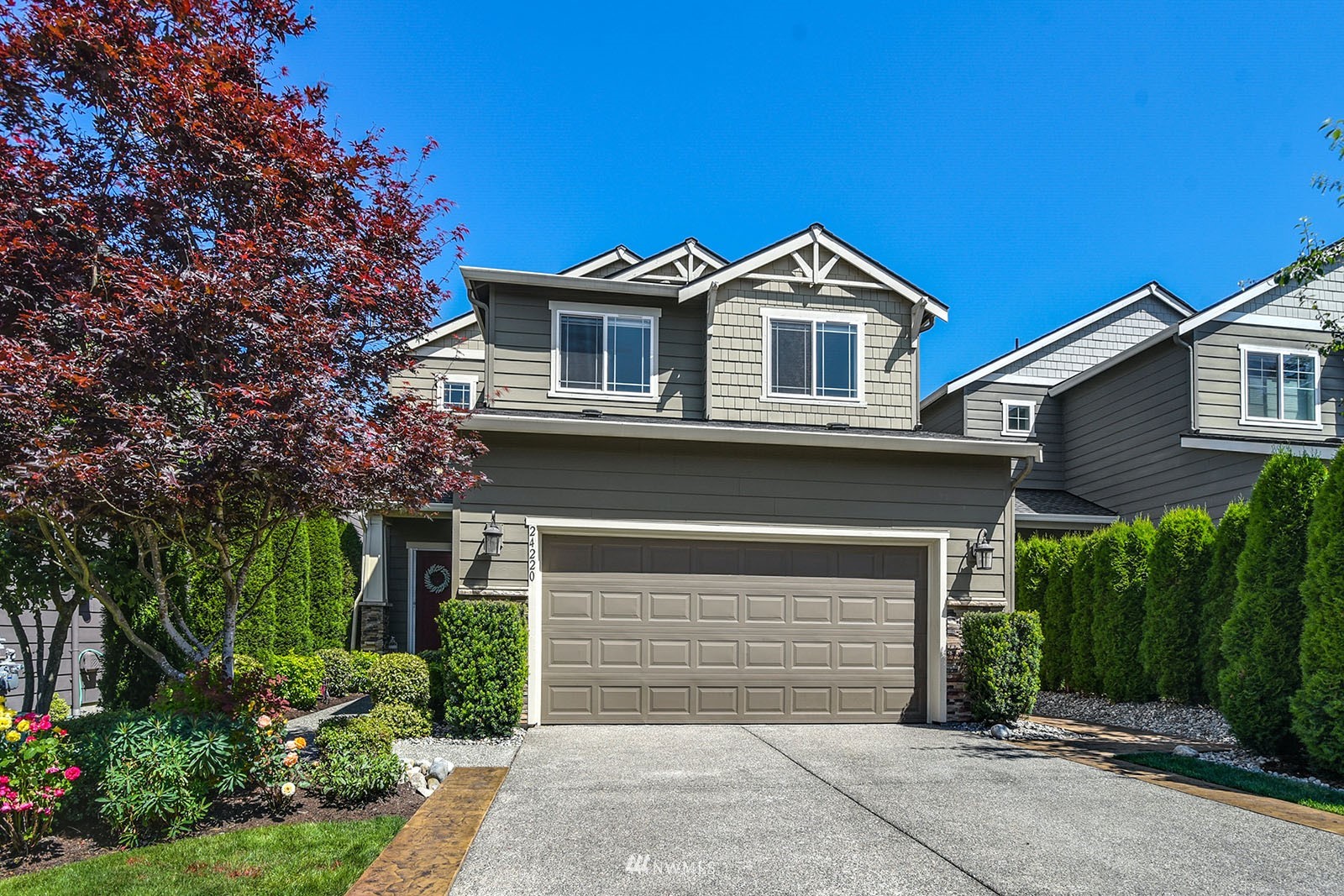 24220 Southeast 258th Way Maple Valley, WA 98038 - Photo 1 of 28 a front view of a house with a yard