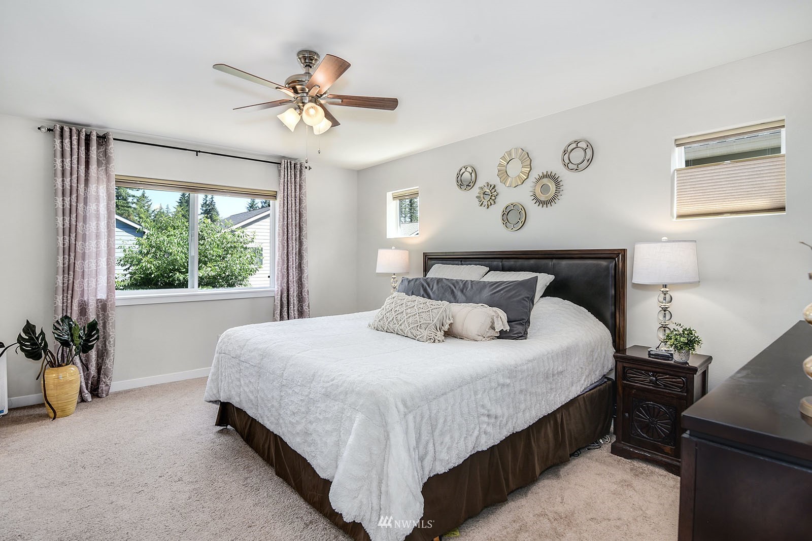 24220 Southeast 258th Way Maple Valley, WA 98038 - Photo 15 of 28 a bedroom with a large bed and a chandelier