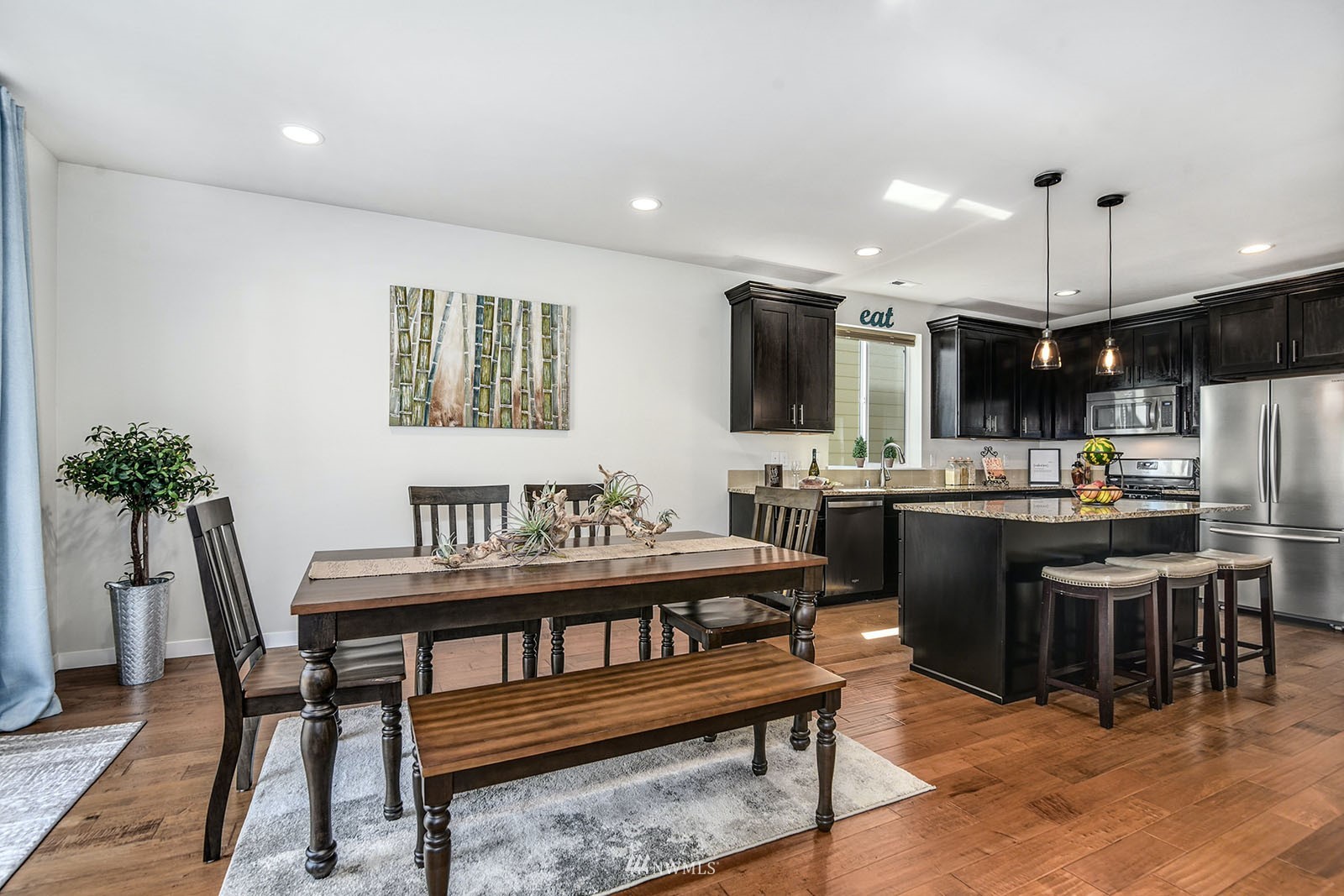 24220 Southeast 258th Way Maple Valley, WA 98038 - Photo 7 of 28 a kitchen with a table chairs refrigerator and microwave