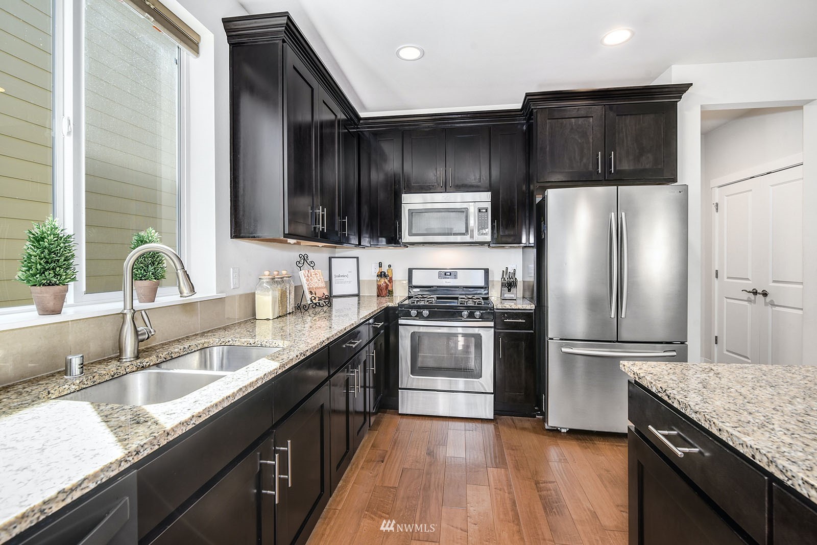 24220 Southeast 258th Way Maple Valley, WA 98038 - Photo 10 of 28 a kitchen with kitchen island granite countertop a refrigerator stove and sink