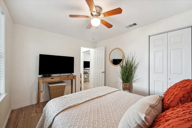 a bedroom with a large bed and a chandelier