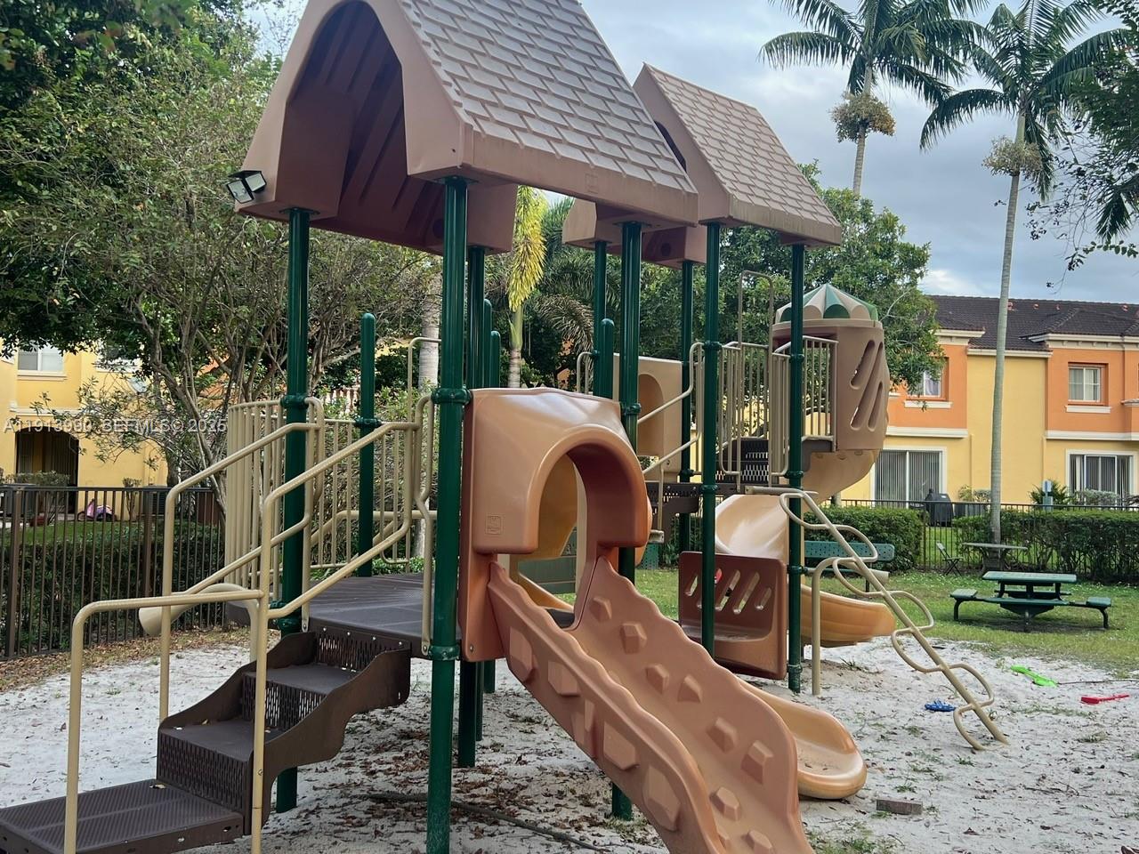 8948 Southwest 19th Street, Unit 909 Miramar, FL 33025 - Photo 28 of 31 a view of a patio with table and chairs under an umbrella with a small yard
