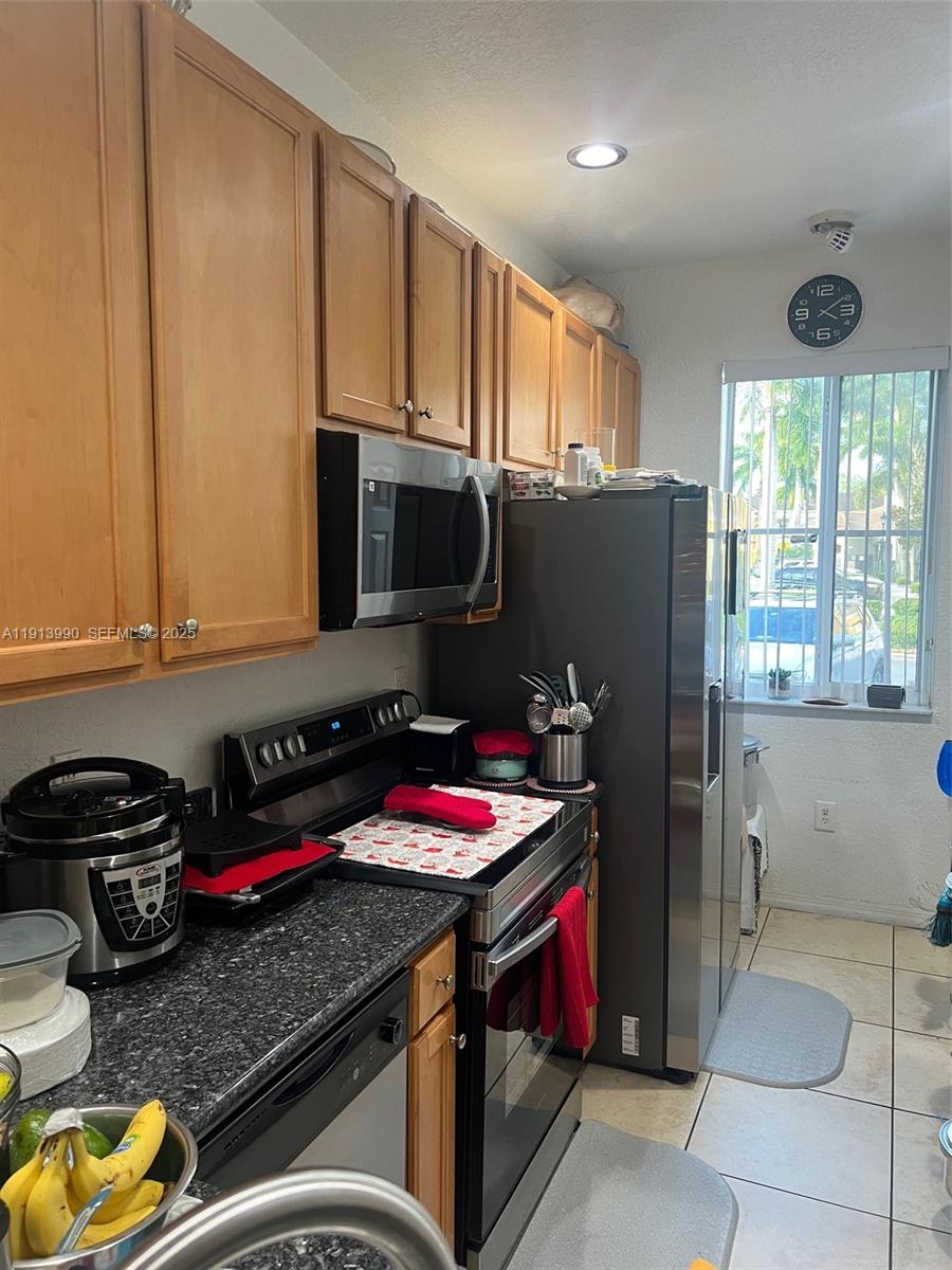 8948 Southwest 19th Street, Unit 909 Miramar, FL 33025 - Photo 5 of 31 a kitchen with stainless steel appliances granite countertop a refrigerator stove and sink