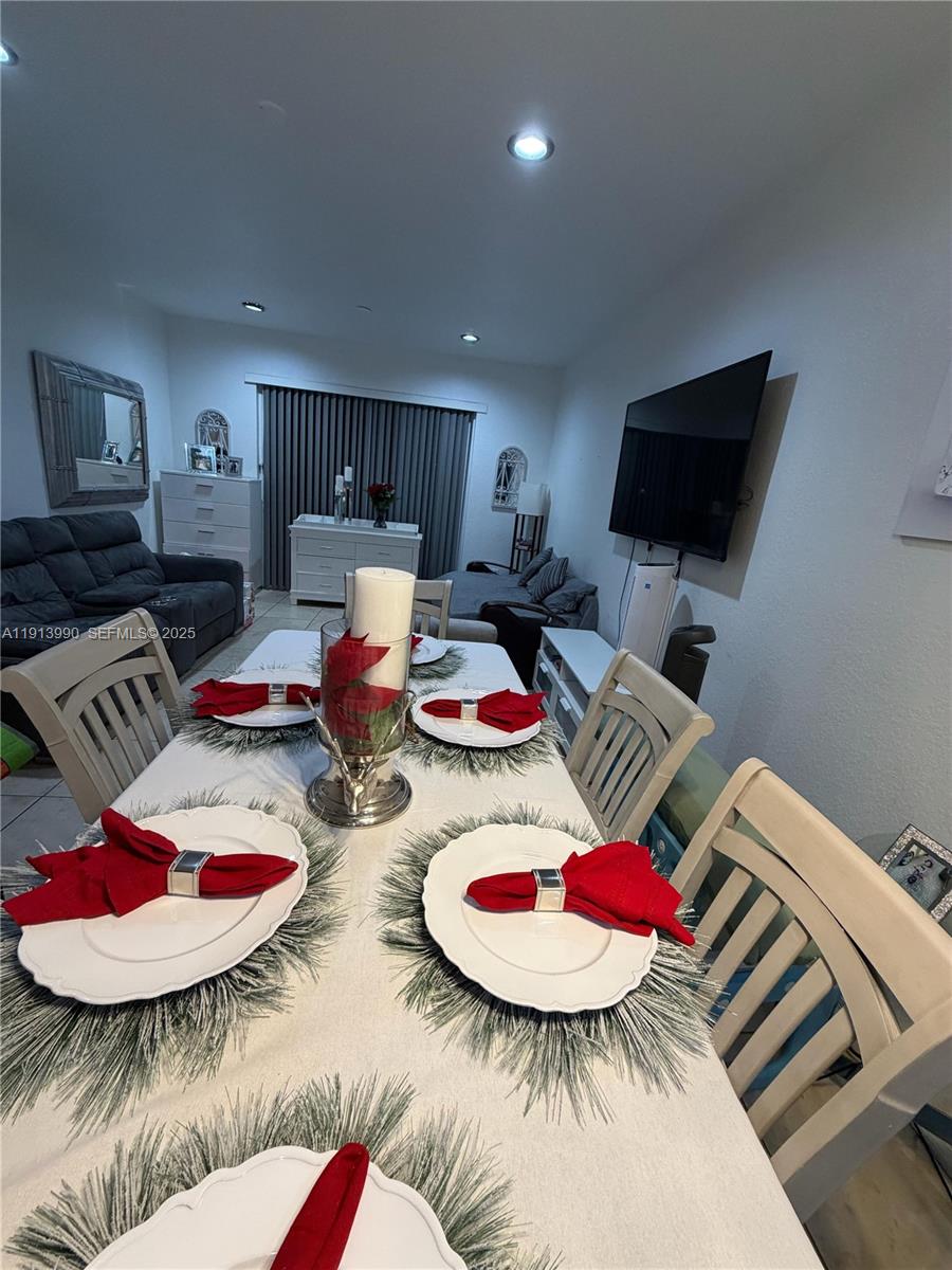 8948 Southwest 19th Street, Unit 909 Miramar, FL 33025 - Photo 6 of 31 a table room with furniture and a flat screen tv