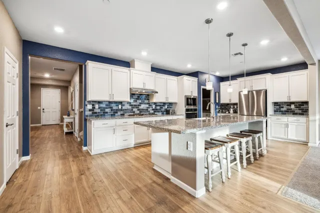 a kitchen with stainless steel appliances a refrigerator sink and cabinets