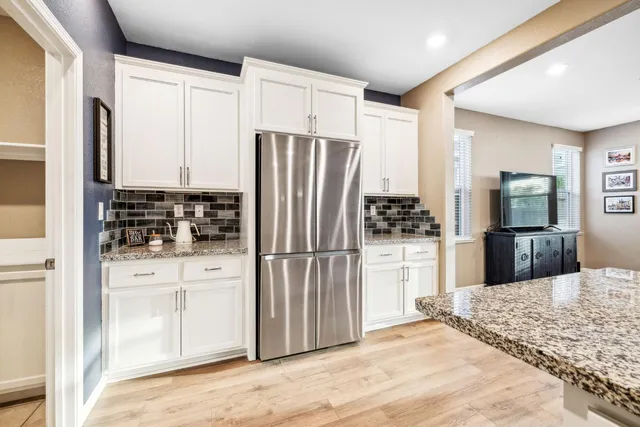 a kitchen with granite countertop white cabinets and white appliances