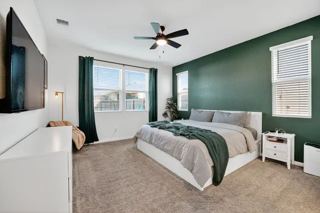 a spacious bedroom with a bed and a large window